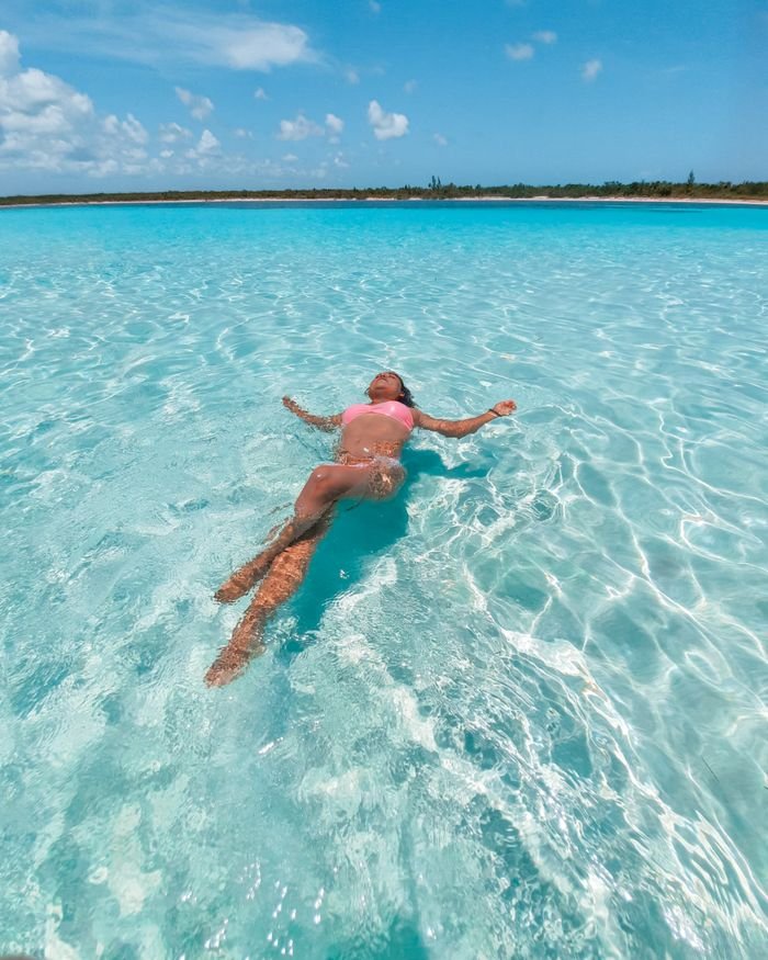A woman floating in swimsuit in the bright turquoise waters of San Miguel de Cozumel. ¿Cuántos días se recomienda estar en Cozumel?